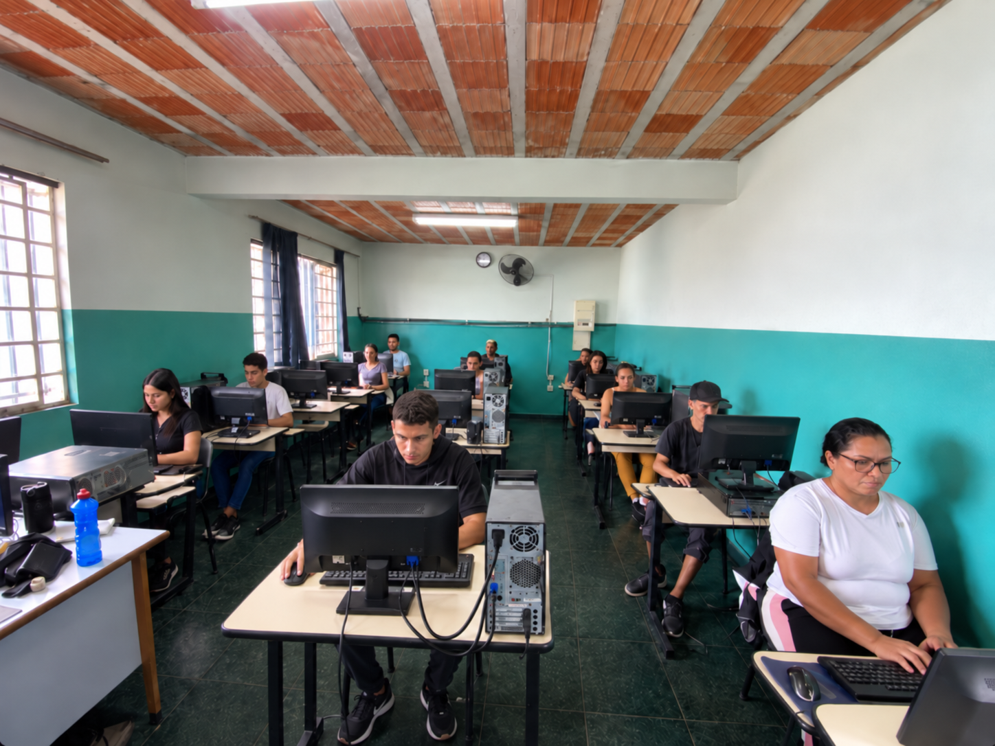 Turma de alunos em uma sala de informática, cada um utilizando um computador individual