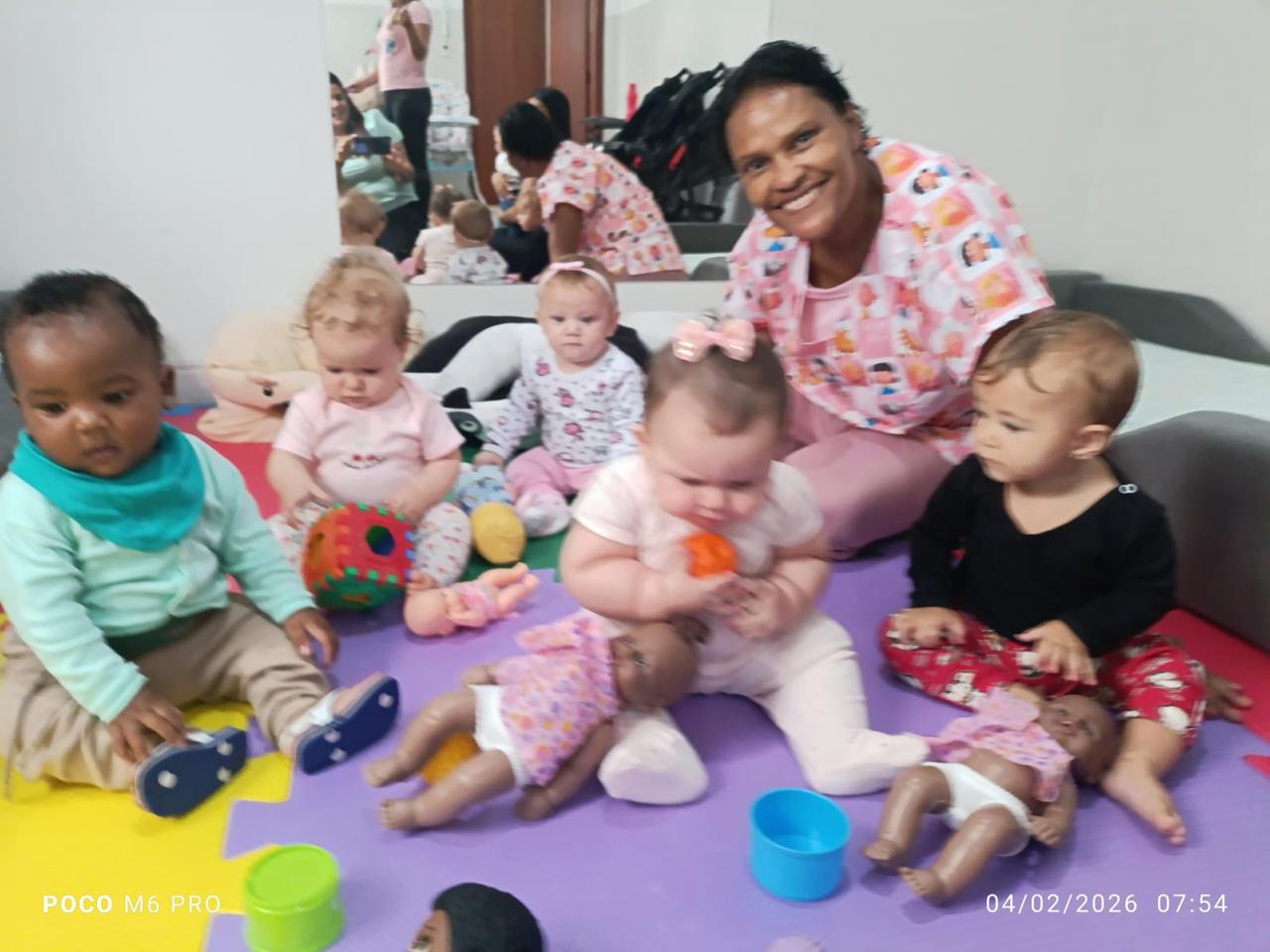 Bebés do berçário brincando com a cuidadora