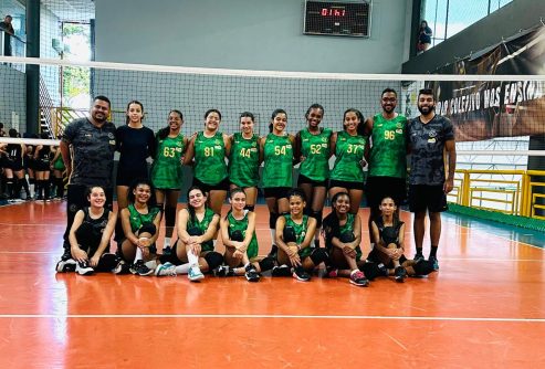 Equipe de vôlei do GDECOM reunida em quadra, com adolescentes e educadores usando uniformes verdes